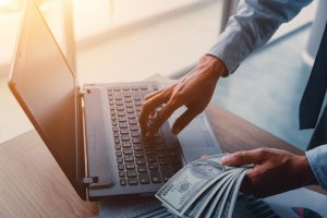 Businessman with cash dollars - business concept,computer and finance,investment,save.